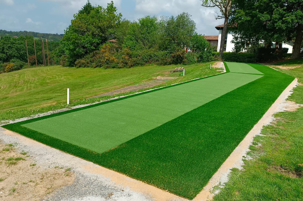 Asheville Outdoor tee line consisting of one continuous green synthetic grass strip surrounded by trees