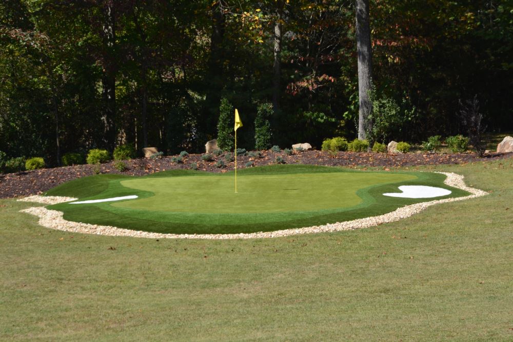 an artificial grass putting green with an artificial grass sand bunker on the left and right sides
