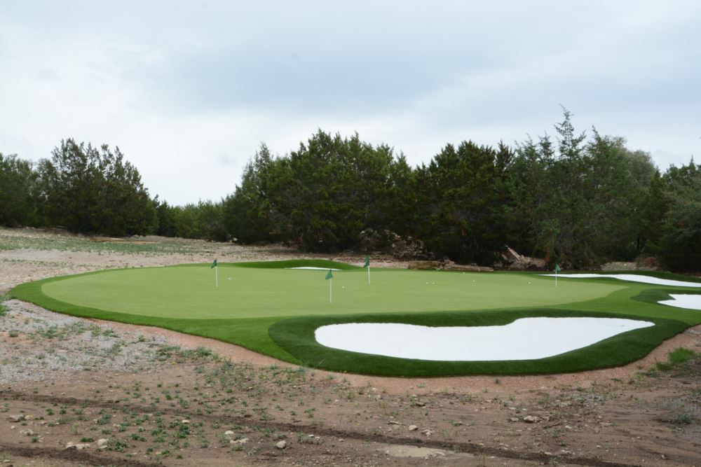 an artificial grass putting green with an artificial grass sand bunker