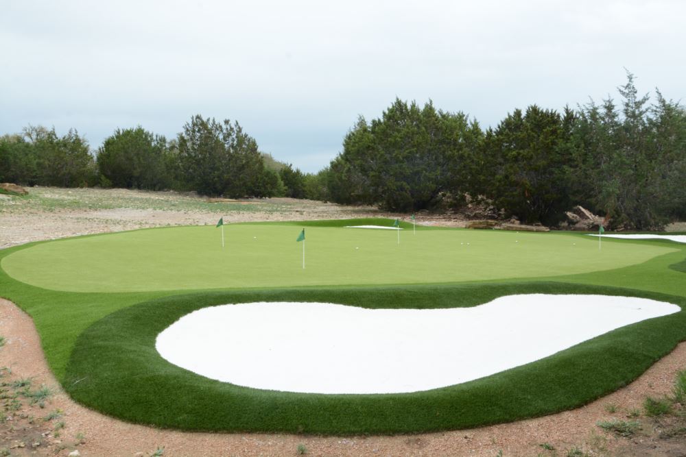 an artificial grass putting green with an artificial grass sand bunker