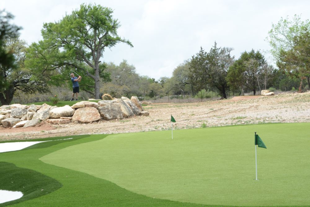 an artificial grass putting green with an artificial grass sand bunker on the left side