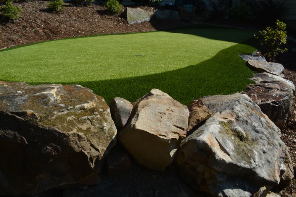 artificial turf used in a putting green with a few different rocks in the forefront